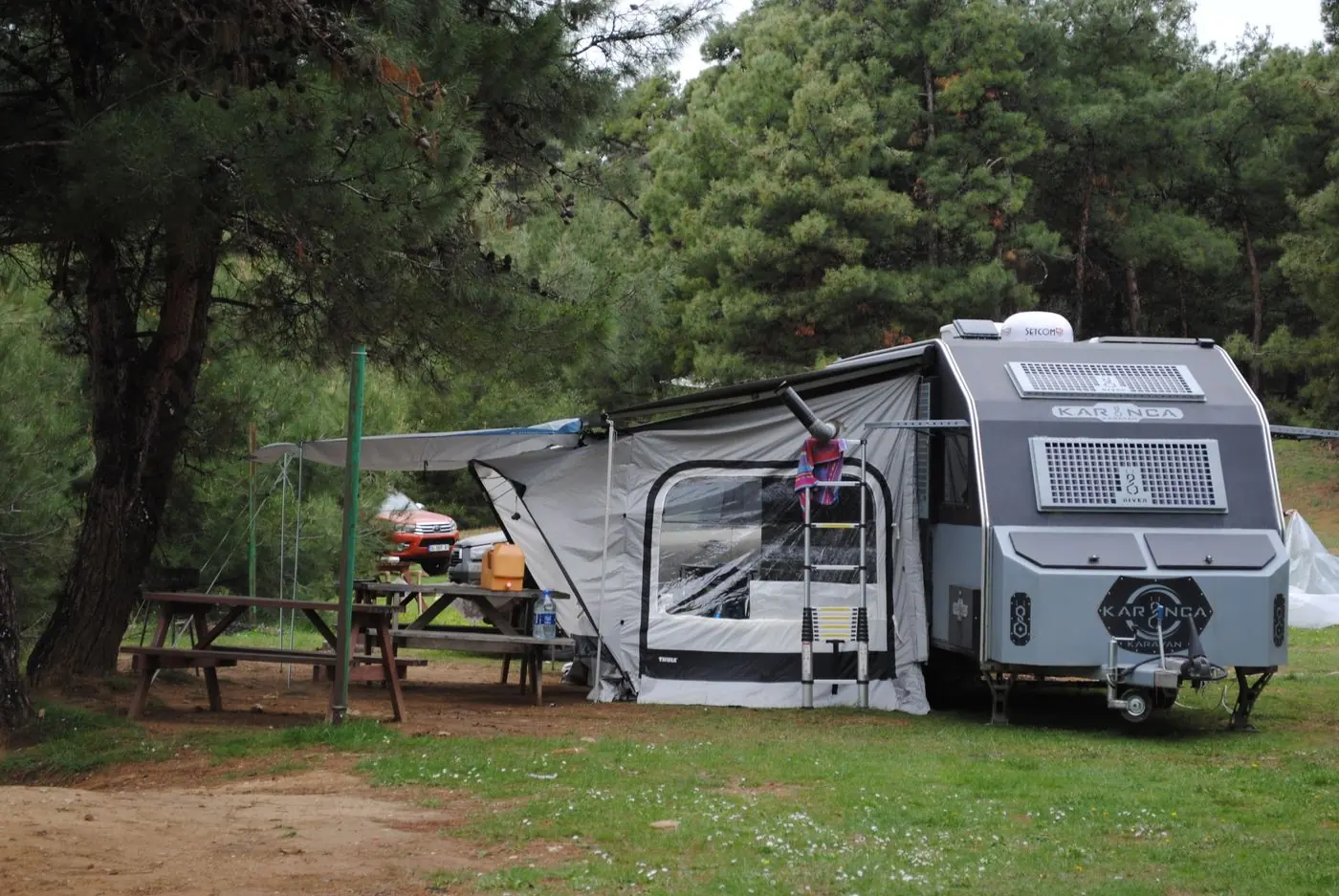 Caravane installée dans un camping paisible entouré d'arbres