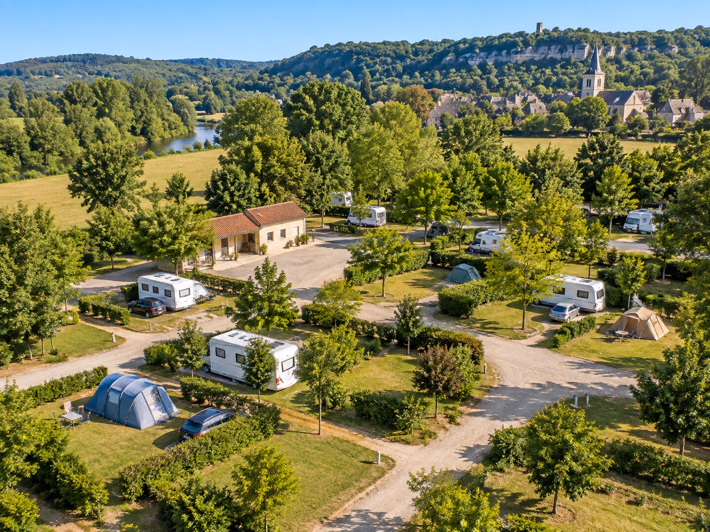 Vue aérienne d’un camping municipal en France avec emplacements, tentes, caravanes et camping-cars