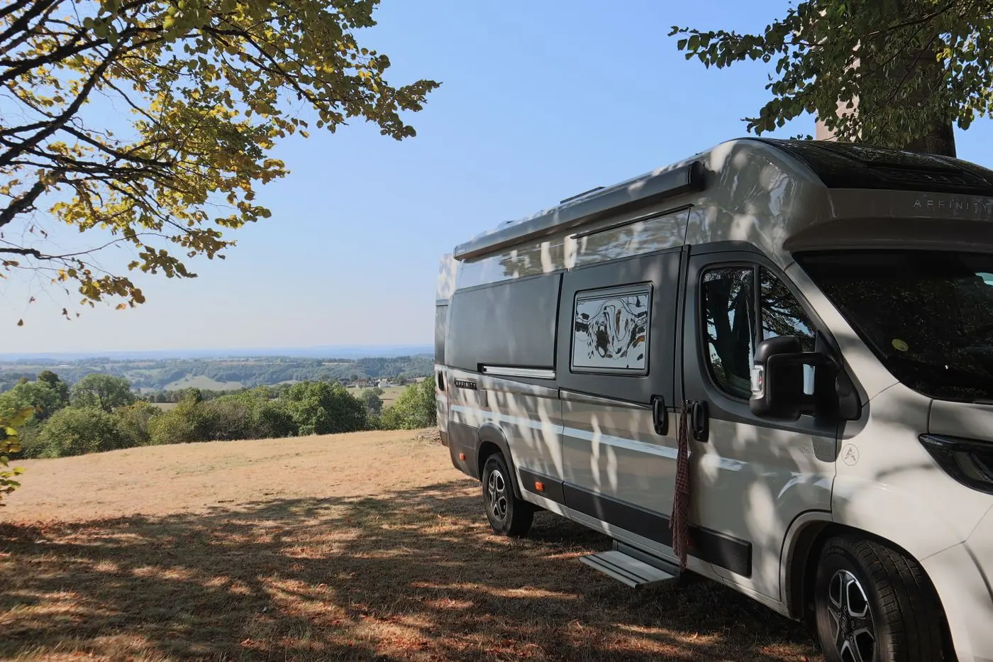 Camping-car stationné sous un arbre dans la campagne française